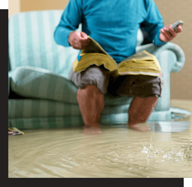 A man sitting on the floor holding a remote control.