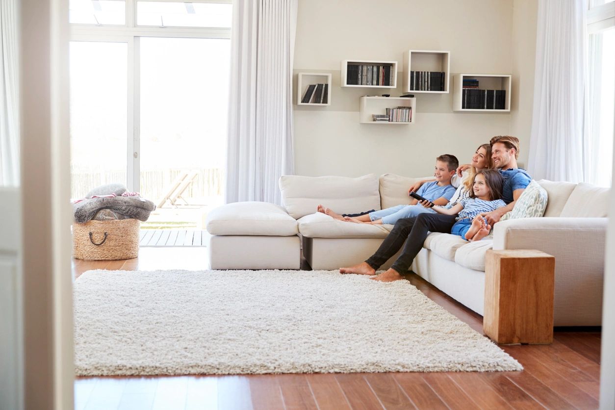 A family sitting on the couch in their living room